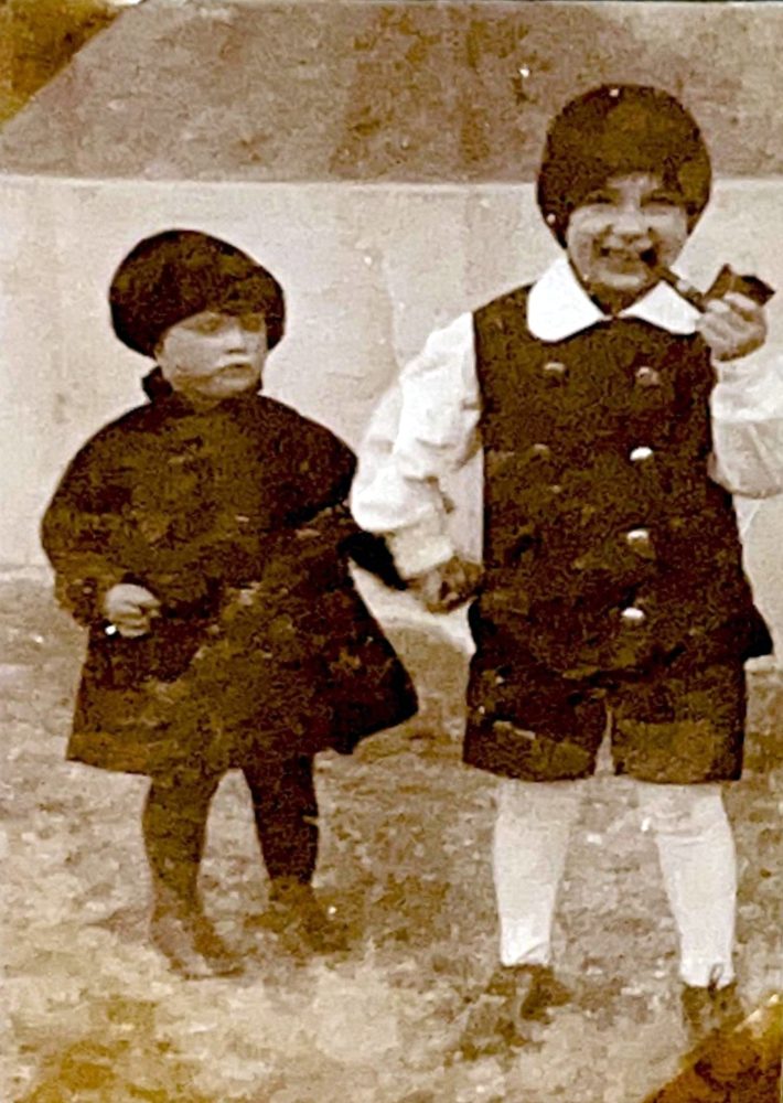 Zwei kleine Kinder in Kostümen, der Junge mit Pfeife
